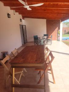 Une table et des chaises en bois sont disponibles sur la terrasse. dans l'établissement Hermosa Casita paso patria III, à Paso de la Patria