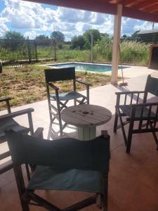 um pátio com uma mesa e cadeiras e uma piscina em Hermosa Casita paso patria III em Paso de la Patria