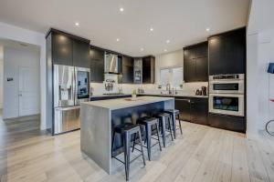 a kitchen with a large island with bar stools at Rivertrail Retreat in Kitchener
