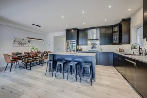 a kitchen and dining room with a blue island in the middle at Rivertrail Retreat in Kitchener