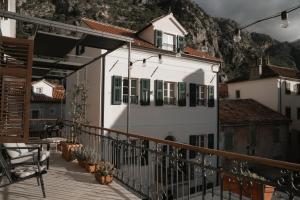 a white house with green shutters on a balcony at Nest 382 in Kotor