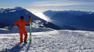 a man holding a snowboard on top of a mountain at Casa Renzo in Arco