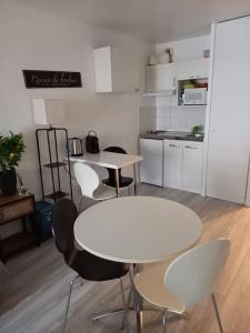a kitchen with white tables and chairs in a room at Bottero-Joli Studio avec terrasse 5 mins de la mer in Nice