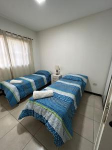 three beds are lined up in a room at Elegante departamento en Mendoza in Mendoza