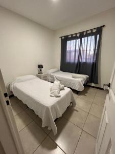 a bedroom with two beds and a window at Elegante departamento en Mendoza in Mendoza