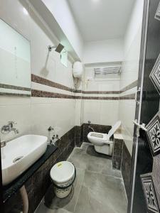 y baño con lavamanos, aseo y lavamanos. en Hotel Pleasure, en Surat