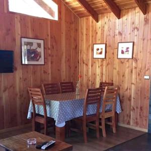 una sala da pranzo in legno con tavolo e sedie di Cabañas sueños del sur a Caburgua