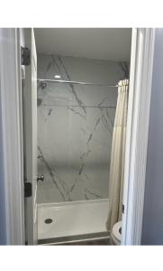 Łazienka z marmurową zasłoną prysznicową i toaletą w obiekcie Sky Inn Hotel w mieście Birmingham