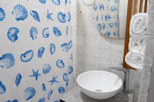 a bathroom with a toilet and a blue and white shower curtain at HOTEL GANADERO in La Dorada +79 photos