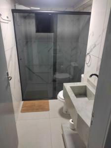 uma casa de banho com um chuveiro, um lavatório e um WC. em Apartamento Central em Ametista do Sul