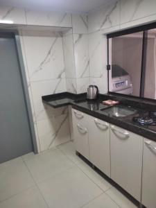 uma cozinha com um lavatório e uma bancada em Apartamento Central em Ametista do Sul