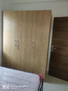 a bedroom with a bed and wooden cabinets at Room2go in Bangalore