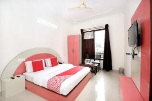 a bedroom with a red and white bed and a tv at Hotel Kamal Palace in Chandīgarh
