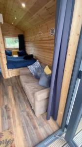 a couch in the inside of a tiny house at The Peregrine - 2 Person Luxury Glamping Cabin in Dungarvan