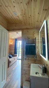 a wooden cabin with a sink and a living room at The Peregrine - 2 Person Luxury Glamping Cabin in Dungarvan