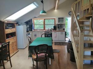 una cocina con una mesa con un mantel verde. en Atelieo beim Nussbaum en Ternitz