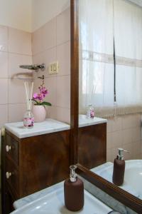 bagno con specchio e lavandino di Casa Don Vito ad Aci Bonaccorsi