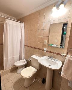 uma casa de banho com um WC, um lavatório e um espelho. em Tiny Room Ingá em Colón