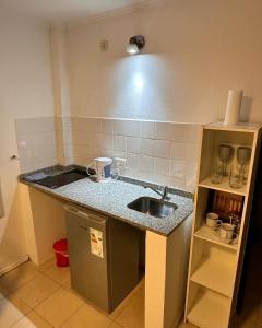a small kitchen with a sink and a refrigerator at Tiny Room Ingá in Colón