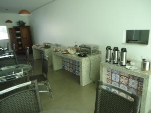 a restaurant with chairs and a counter with food at Hotel Jequitibá in Gurupi