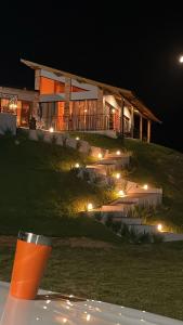 a house on a hill at night with lights at Refúgio nascer das águas in Gravatal