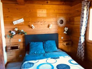 1 dormitorio con 1 cama en una pared de madera en Chalet au calme en Haute Savoie., en Châtillon-sur-Cluses