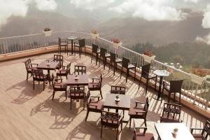 a restaurant with tables and chairs on a balcony at Amazing Hotel Sapa in Sa Pa