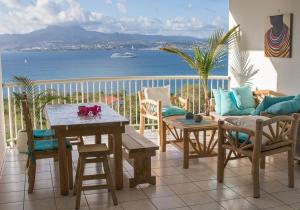 un balcone con tavolo e sedie e vista sull'oceano di T3 résidence les ramiers (anse a l'âne) a Les Trois-Îlets