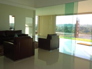 a living room with two couches and a glass wall at Hotel Jequitibá in Gurupi
