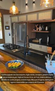 a kitchen with a sink and a counter with a bowl of oranges at Refúgio nascer das águas in Gravatal