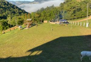 a large field with a playground with a goat at Refúgio nascer das águas in Gravatal