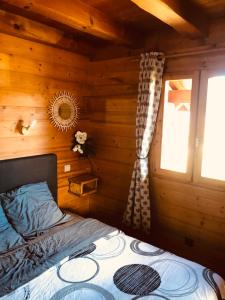 1 dormitorio con 1 cama en una cabaña de madera en Chalet au calme en Haute Savoie., en Châtillon-sur-Cluses