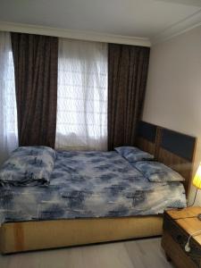 a bedroom with a bed with a blue comforter and a window at Yola hime in Istanbul