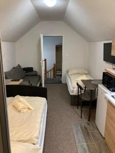 a room with two beds and a kitchen and a living room at Studio Manzarda in Liptovský Mikuláš