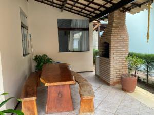 un banco de madera en un patio con chimenea en Casa 08 Quadra 06 Cond. Viva Vida, en Aracaju