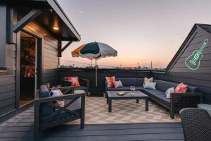 une terrasse avec un canapé, une table et un parasol dans l'établissement Designer Single Family House-Rooftop- Hot Tub, à Nashville