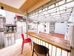 a balcony with a wooden table and two chairs at La Casa Di Decembre in Hanoi