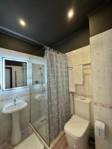 a bathroom with a shower and a toilet and a sink at Misk Hotel & Resort in Tirana