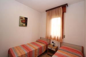 a bedroom with two beds and a window at Mughetto in Bibione