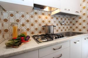 a kitchen counter with a stove and vegetables on it at Mughetto in Bibione