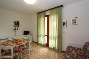 a living room with a table and a window at Mughetto in Bibione