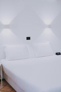 un letto bianco in una camera di Albergo Delle Regioni, Barberini - Fontana di Trevi a Roma