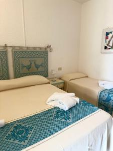 two beds in a small room with two bedsvisor at Hotel Canne al Vento in Santa Teresa Gallura