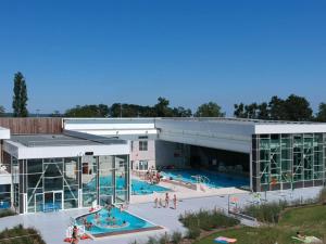 - une vue sur un grand bâtiment avec une piscine dans l'établissement Ferme les Iris, à Issenheim