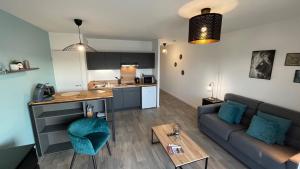 a living room and kitchen with a couch and a table at La Bri'Z de Dinard in Dinard