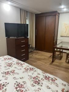 Flat no Itaim Bibi في ساو باولو: غرفة فندقية بسرير وتلفزيون بشاشة مسطحة