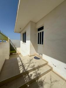 un edificio blanco con una puerta y unas escaleras en RESIDENCIAL EUNICE en Praia