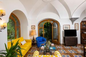 a living room with a yellow couch and a blue chair at Casa Mercè Positano in Positano