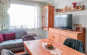 a living room with a table and a television at Beautiful Apartment In Mhlbach Am Hochknig With Kitchen in Mühlbach am Hochkönig