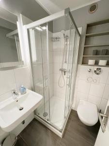 a bathroom with a shower and a sink and a toilet at Ferienwohnung Westerland strandnah Balkon Strandläufer 1 & 2 in Westerland (Sylt)
